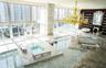 Floor-to-ceiling windows, stone-clad flooring, multiple sunken spa basins, an expansive tiered stone deck, and a feature wall with integrated floor-to