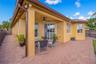 Covered patio featuring a herringbone-patterned brick paver floor, built-in ceiling fan, stucco exterior, and multi-pane windows