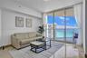 Floor-to-ceiling sliding glass doors, private balcony, polished stone tile flooring, and neutral wall finish