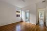 Room featuring wood-finish flooring, a ceiling fan, a window, and an attached bathroom with a shower-tub combination