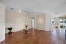 Open-concept living space featuring wood-finish flooring, adjustable track lighting, an arched doorway, and glass sliding doors providing exterior exp