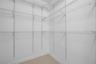 Walk-in closet featuring white wire shelving, multi-level storage racks, and neutral tile flooring