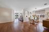 Wood-finish flooring, architectural arched wall niches, sliding glass patio doors, and multi-light linear ceiling fixture