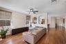 Wood-finish flooring, built-in dark cabinetry, dual architectural wall cutouts, and a ceiling-mounted light fixture with a fan