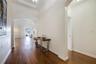 Entryway featuring wood-finish flooring, recessed tray ceiling, and arched architectural openings