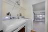 Laundry area featuring overhead wire shelving and wood-finish flooring