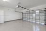 Garage featuring finished tile flooring, white-painted walls, and an automated garage door opener system