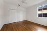 Wood-finish flooring, dual bi-fold closets, and ceiling fan with integrated lighting