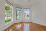 Bay window featuring arched multi-pane glass, wood-finish flooring, and white interior wall surfaces