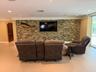 Living room wall has a striking rock feature with mahogany framed in sunken TV area
