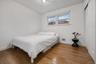 Neutral-toned room featuring wood-finish flooring, a double-hung window, and a closet with sliding panel doors
