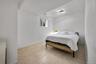 Neutral interior space featuring large-format ceramic tile flooring, a window with exterior exposure, and a flush-mount circular ceiling light fixture