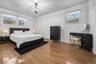 Spacious room featuring wood-finish flooring, multi-pane windows, and a central spherical pendant light fixture
