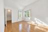 Vaulted ceiling room featuring wood-finish flooring, recessed lighting, and multi-pane windows