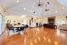 Vaulted ceiling with recessed lighting, wood-finish flooring, stone-surround fireplace, and multiple windows