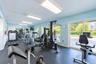 Fitness center featuring rubber flooring, recessed fluorescent lighting, and large sliding glass doors
