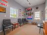 Sitting room with track lighting, healthy amount of natural light, a drop ceiling, and a baseboard heating unit