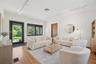 Living space featuring wood-finish flooring, track lighting, and a glass-panel exterior door with metal frame