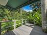 Covered deck featuring composite wood-finish decking, post-and-rail wood fencing, and a retractable fabric awning