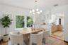 Dining area featuring wood-finish flooring, a contemporary multi-globe chandelier, and large windows