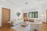 Living space featuring wood-finish flooring, white walls, track lighting, and black-framed windows