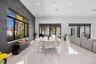 Spacious interior featuring large-format tile flooring, a charcoal-toned textured accent wall, recessed lighting, and multiple sliding glass door syst