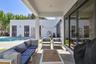 Covered patio featuring concrete flooring, sliding glass door systems, recessed ceiling lighting, and overhead string lights, situated near a swimming