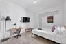 Neutral-toned tile flooring, high ceilings, and floor-to-ceiling roller shades