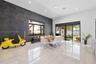 Living area featuring high ceilings, large-format tile flooring, a charcoal-toned accent wall, and sliding glass doors leading to the exterior