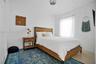 Neutral-toned walls, ceiling-mounted decorative light fixture, single-panel door, and window with rod-mounted drapery