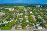 Aerial perspective featuring a corner lot location, mature trees, and proximity to coastal waters