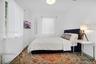 Neutral interior space featuring white walls, two double-hung windows, and a flush-mount ceiling light fixture