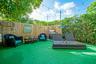 Fenced backyard featuring wood-plank fencing, built-in outdoor grill, and overhead string lighting