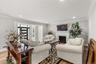 Living area featuring light wood-style flooring, a brick fireplace, crown molding, and recessed lighting