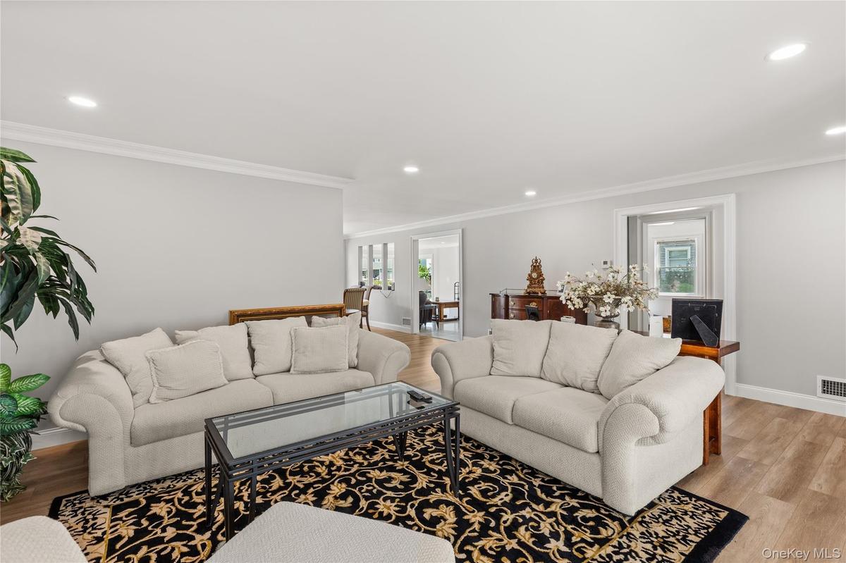 Living area featuring light wood-style flooring, recessed lighting, and crown molding