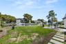 View of property's community featuring a water view, a residential view, a yard, and a patio