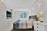 Built-in custom cabinetry with integrated shelving, recessed ceiling lighting, tray ceiling detail, large-format tile flooring, and oversized windows