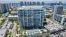 High-rise residential building featuring floor-to-ceiling glass paneling, a multi-level concrete facade, and an elevated outdoor swimming pool with ma