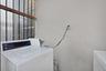 Utility area featuring metal security bars over the window and an electrical outlet