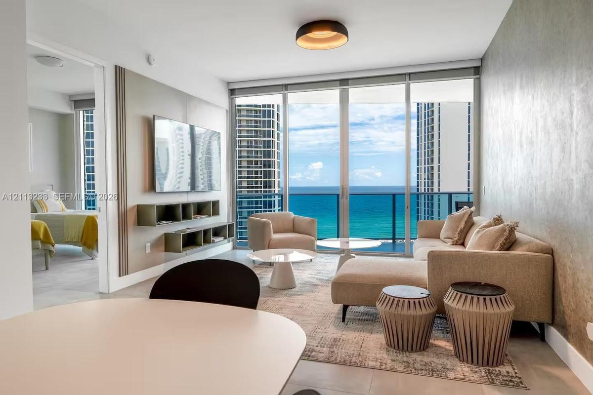 Floor-to-ceiling glass doors, wall-mounted built-in shelving, textured accent wall, and recessed ceiling lighting
