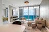 Floor-to-ceiling glass doors, wall-mounted built-in shelving, textured accent wall, and recessed ceiling lighting