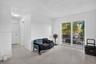 Interior space featuring polished stone-aggregate flooring, white walls, and a large sliding glass door with a metal balcony railing