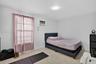 Room featuring light-toned interior walls, neutral speckled flooring, a mounted air conditioning unit, and a flush-mount ceiling light