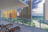 Covered balcony featuring tile flooring and a glass panel railing