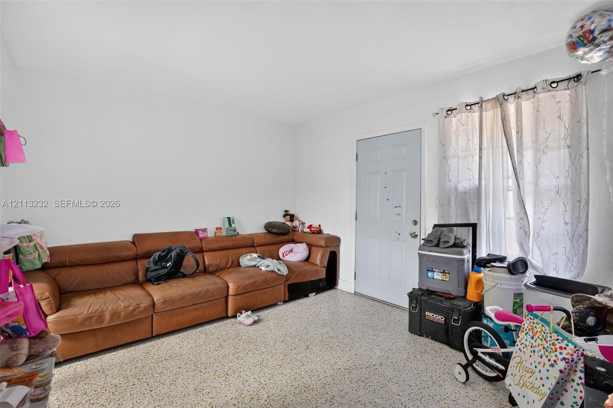 Neutral-toned interior room featuring terrazzo flooring and a multi-panel exterior entry door