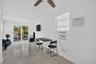 Polished terrazzo flooring, sliding glass door access to a balcony, and a ceiling fan with wood-finish blades