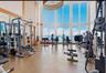 Fitness area featuring floor-to-ceiling windows, high ceilings, large-format tile flooring, and wall-to-wall mirrors