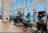 Fitness center featuring floor-to-ceiling windows, a stacked stone column, and neutral flooring
