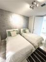 Bedroom featuring stone flooring, textured wall covering, and a multi-directional track lighting fixture