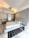 Textured grey feature wall with stone-finish flooring and floor-to-ceiling mirrored closet doors